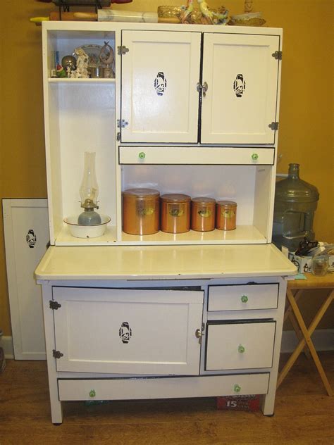 Hoosier cupboard - This classic American antique from about 1910 is a solid oak signed"Hoosier" kitchen cabinet from Indiana with the original tambour roll top doors and a flour sifter. The deep brown finish is in excellent condition. The porcelain enamel work surface pulls …